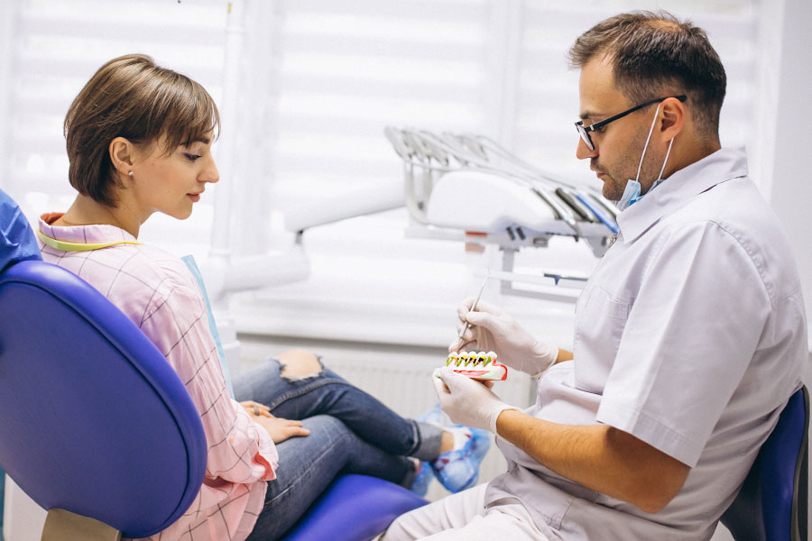 Dentist showing a model diagram of a cavity to a patient