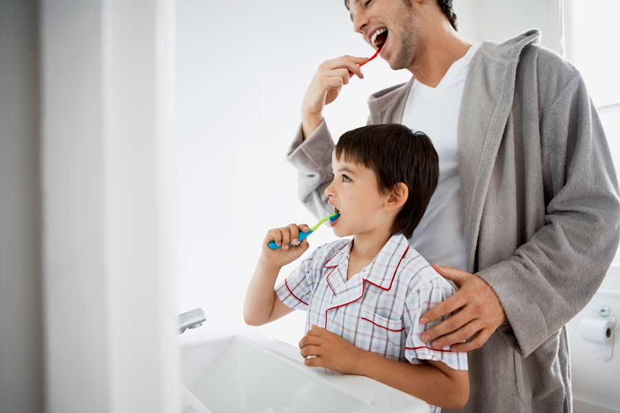 Father and son engaging in quality dental care routine together for child dental care in San Marcos